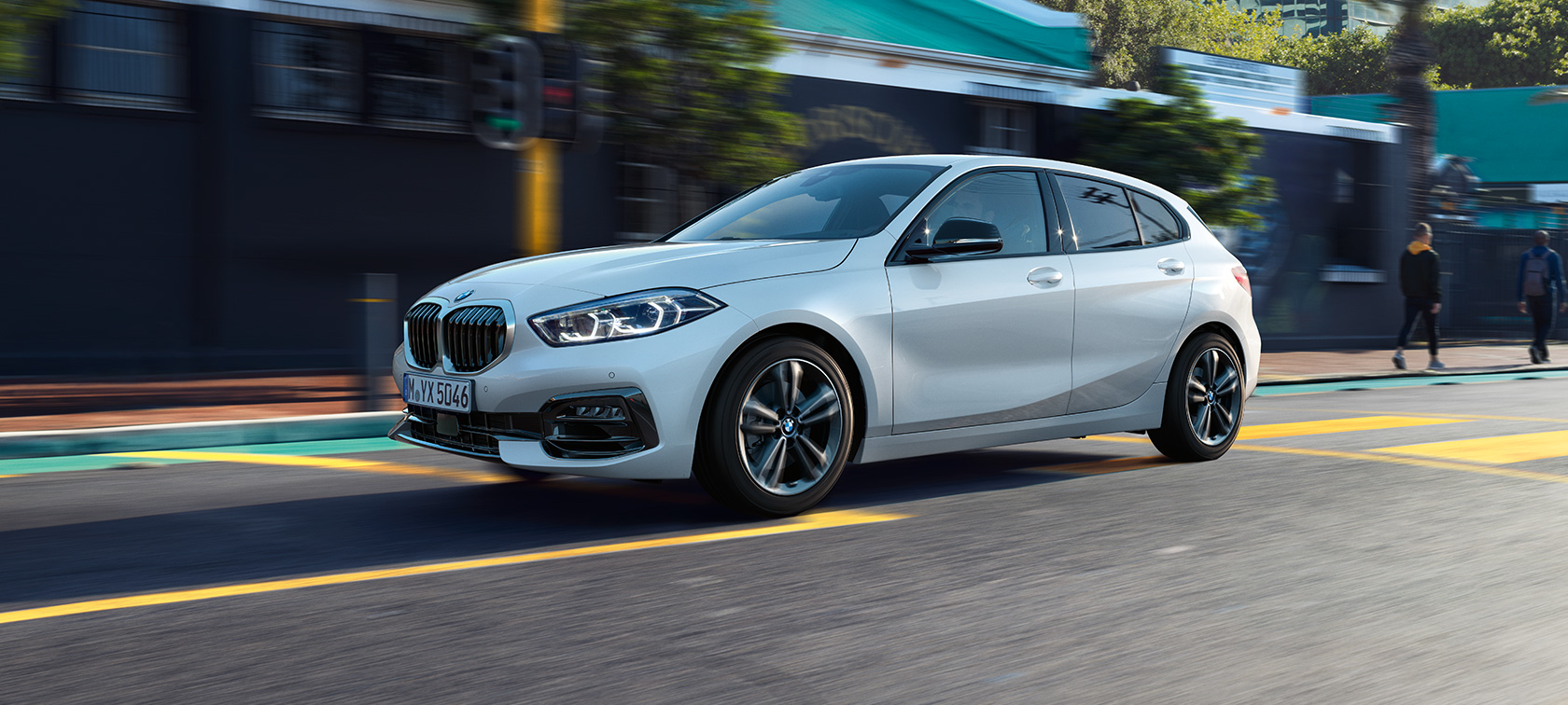 BMW 1 Series Model Sport Line in Mineral White metallic, three-quarter side view, driving.