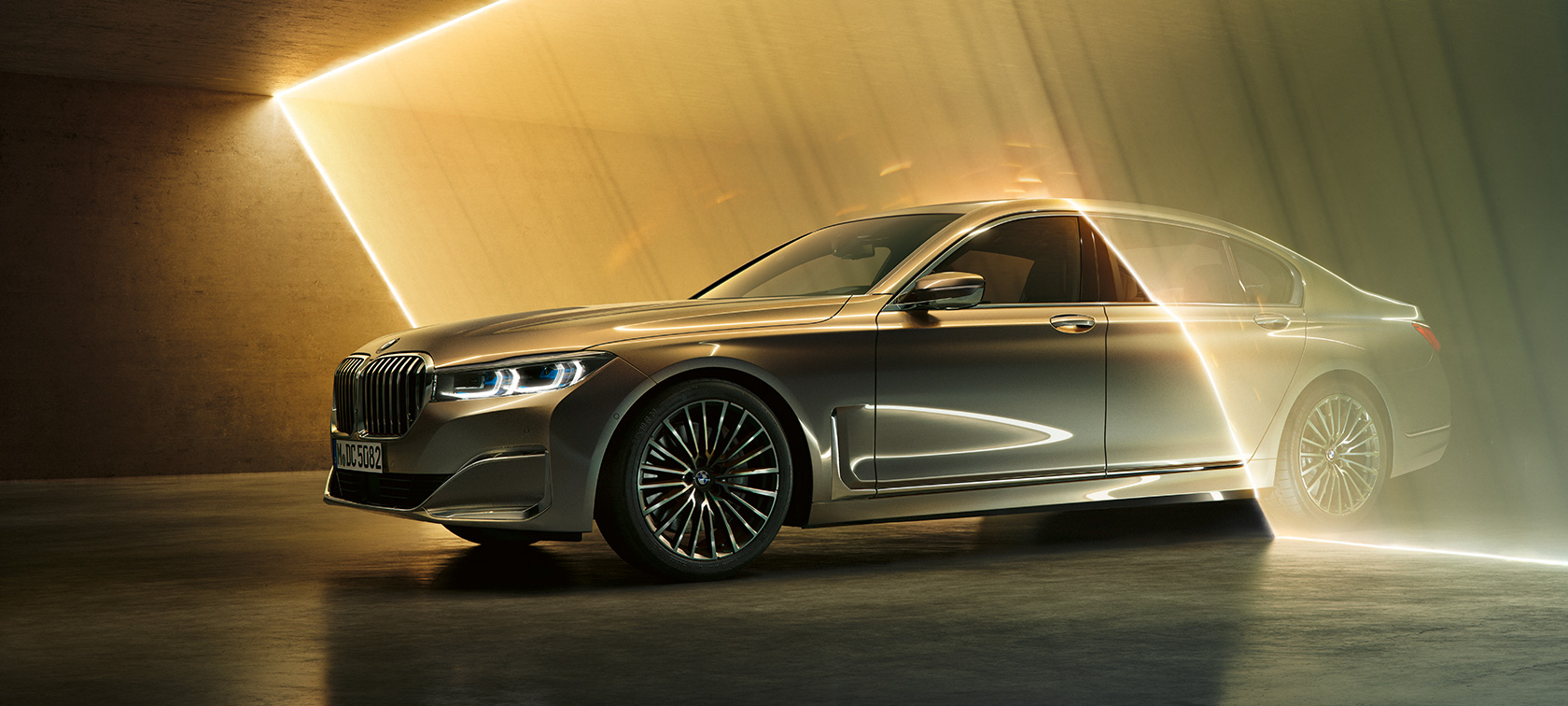 BMW 7 Series Sedan: grey BMW in three-quarter front view surrounded by beams of light