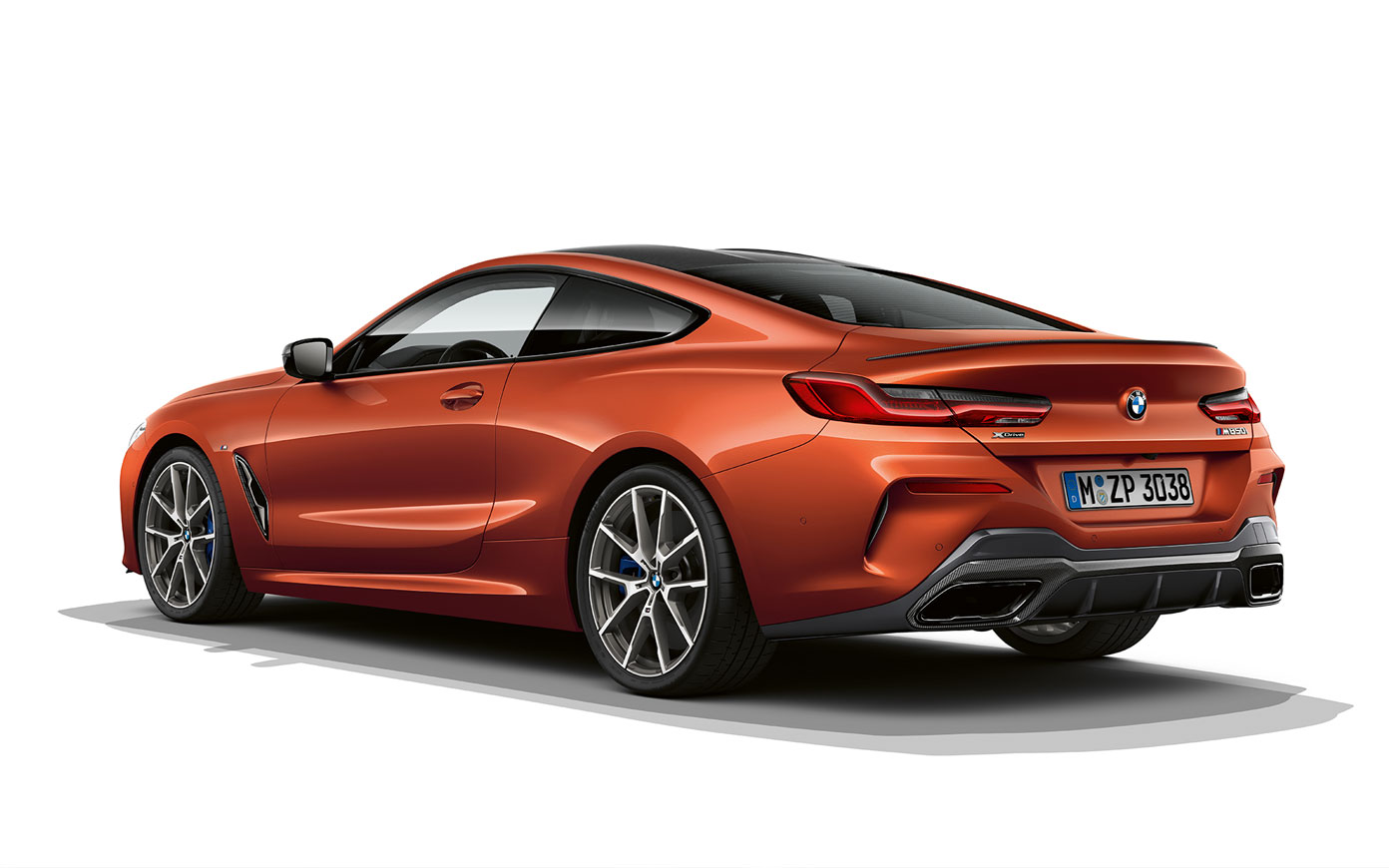 A still shot of the BMW 8 Series Coupé in Sunset Orange metallic against a white background.